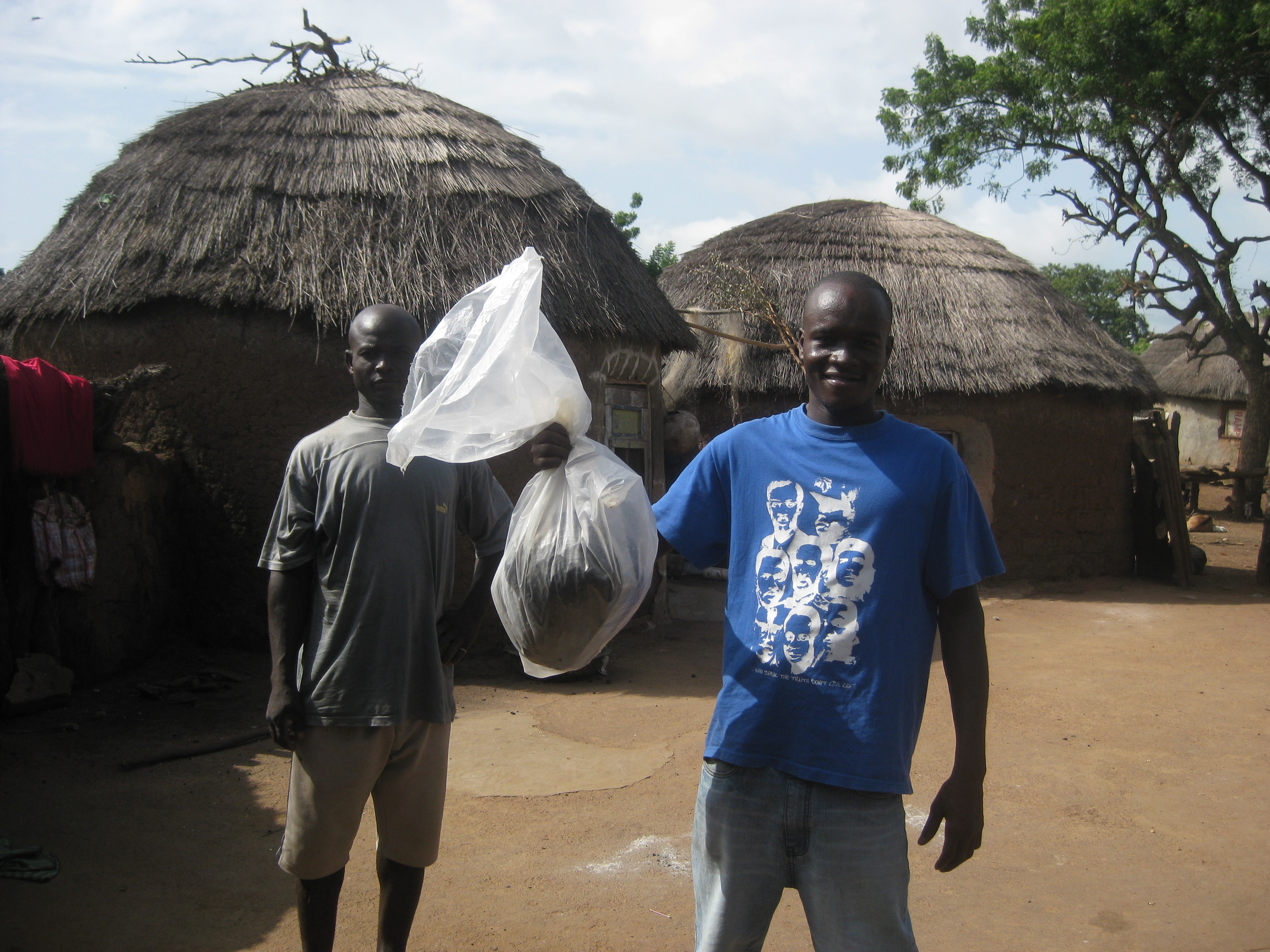 Peter taking home a gift from Hawa (one of the women who work at the Nymaliga water treatment center) and her family - a big bag of groundnuts (peanuts!)
