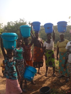 Happy customers on their way home with full buckets of clean drinking water