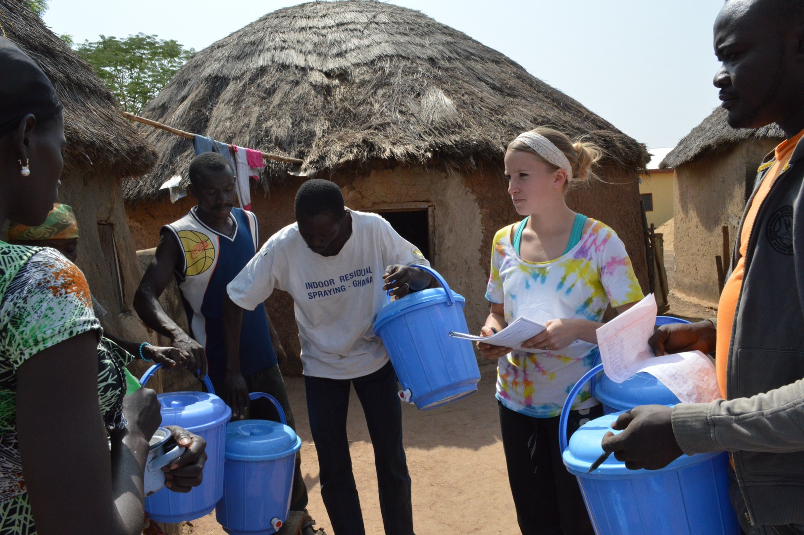Meaghan distributing safe storage containers with the help of some village members