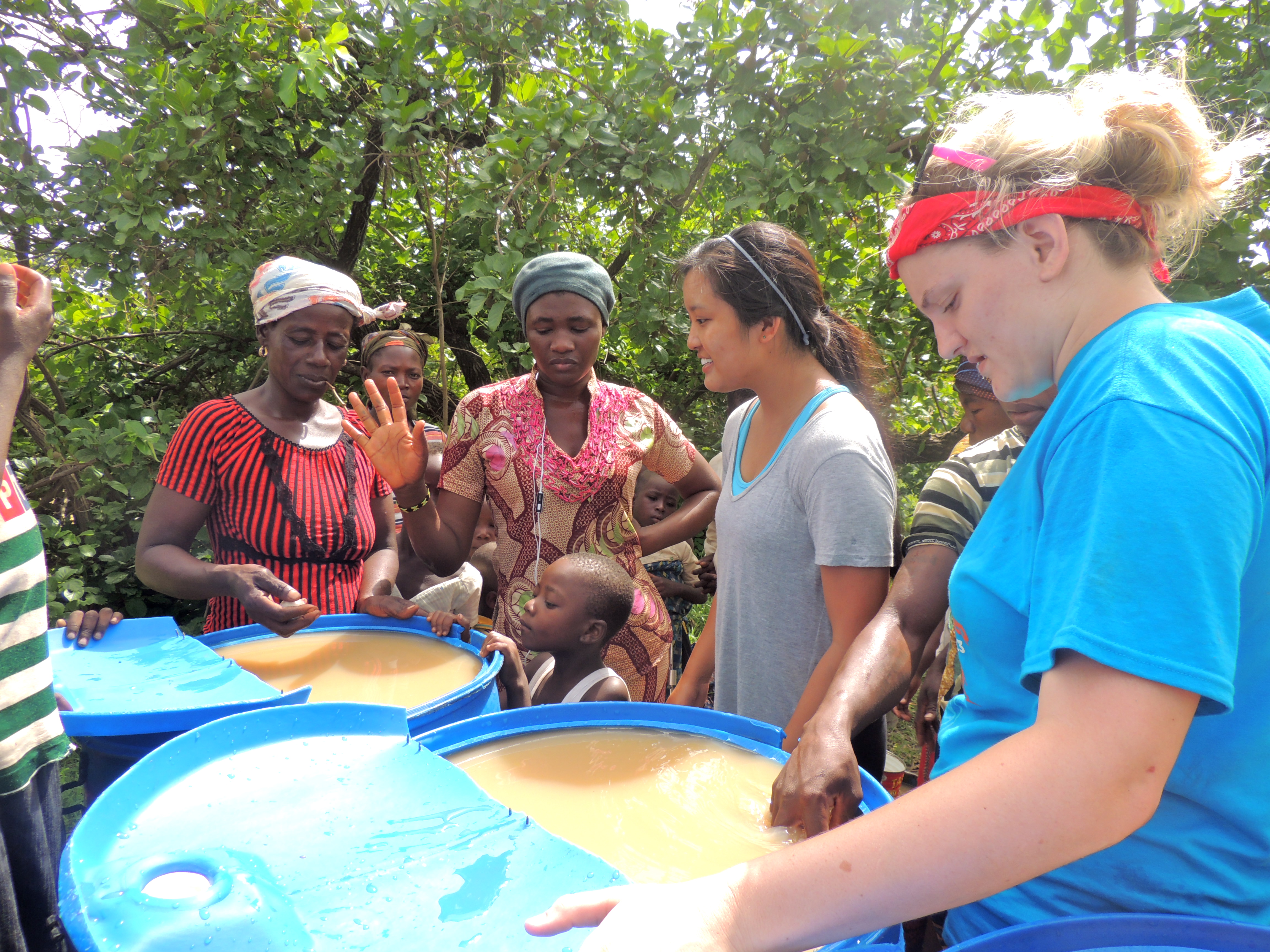 Haley and Caroline teach Bellamina and Damu how to use alum to remove the turbidity from the water.