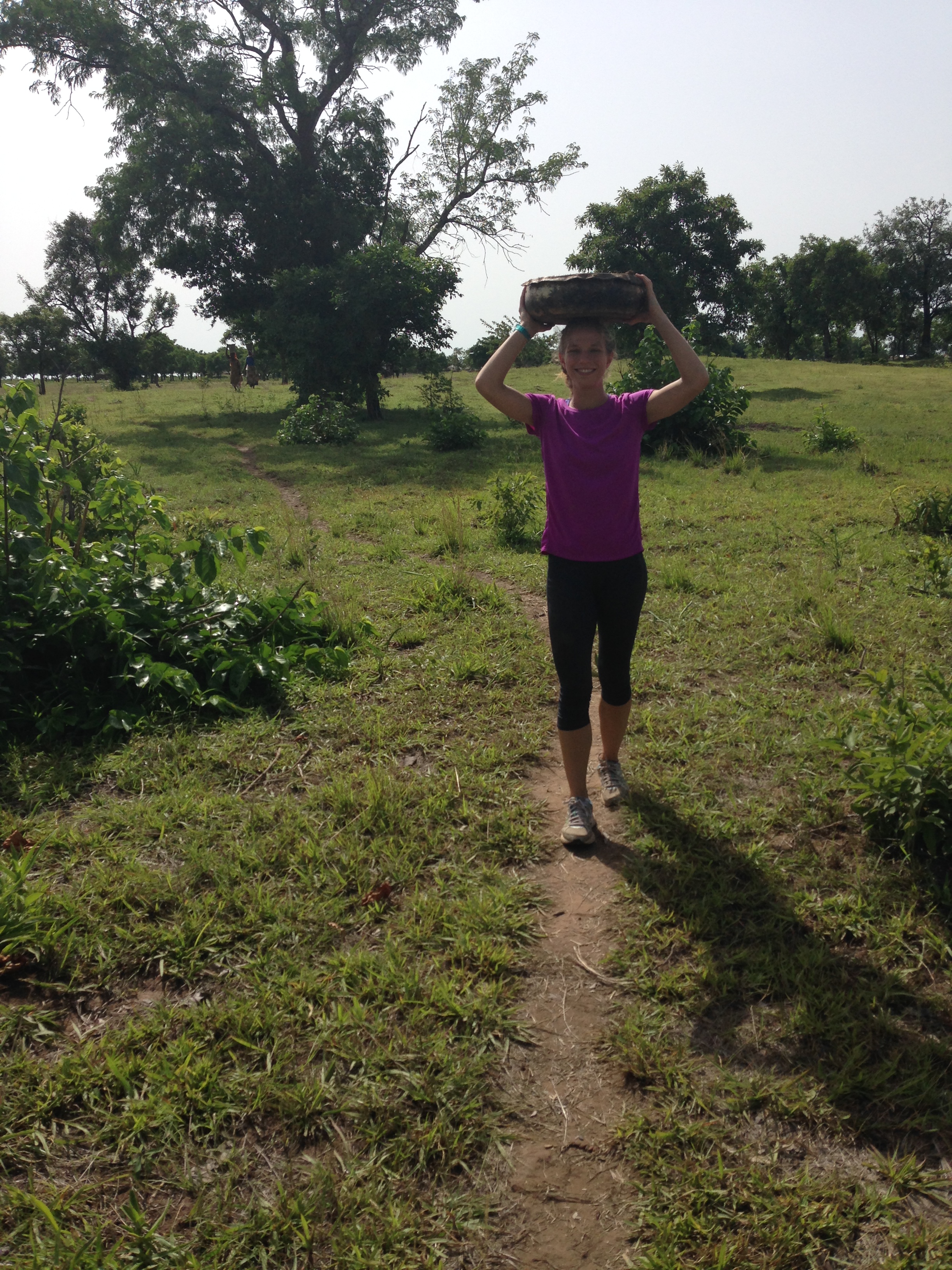 Christina carries some supplies on her head for construction